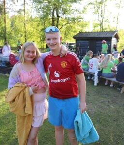 Deltakere står på sletta og smiler.