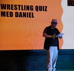 Gutt står på scenen og leder quiz.
