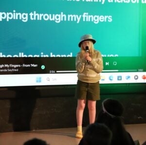 Jente synger karaoke fra scenen.