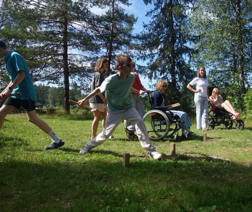 En gjeng spiller energisk kubbspill på sletta.