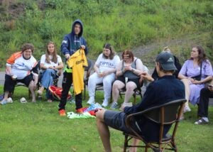 Deltaker viser fram fotballtrøyer til en gruppe med mennesker.