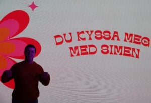 Mann på scenen under show. Smiler til kamera.