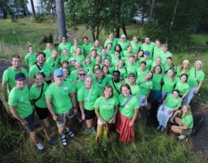 En gruppe smilende mennesker, med like lysegrønne t-skjorter.