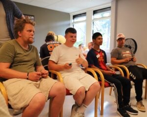 Fire konsentrerte gutter spiller tv-spill. Den ene gutten smiler og viser tommel opp.