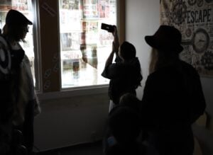 Tre mennesker står og ser på spor inne i et escape room.