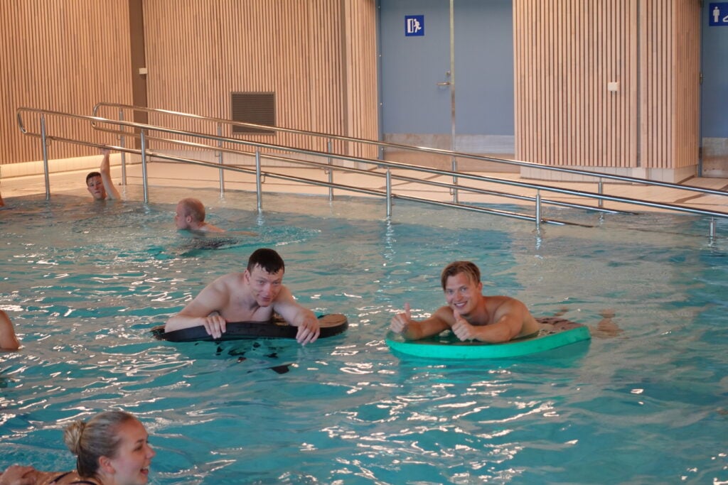 Flere personer som bader i bassenget