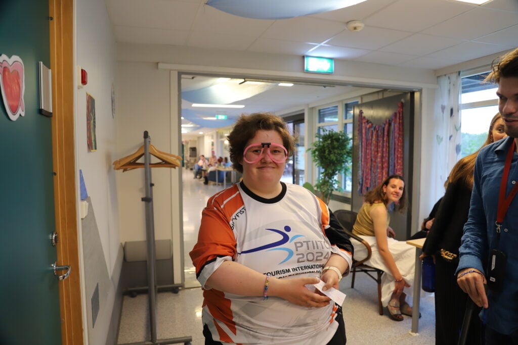 Ung dame sminket og står smilende i gangen