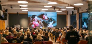 Bilde av fullsatt sal som ser på klipp fra Team Pølsa