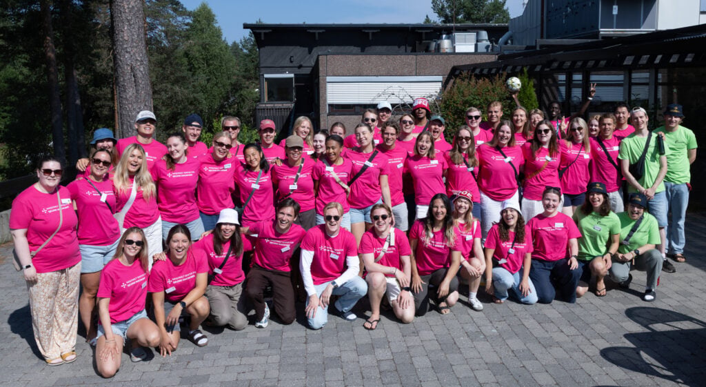Gruppebilde, utendørs, mange unge voksne med rosa t-skjorter