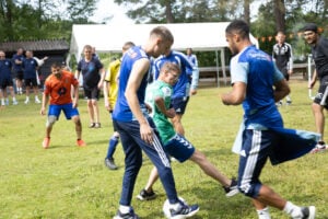 På fotballbane, tre spillere, to av dem med Vålerengadrakt spillr fotball