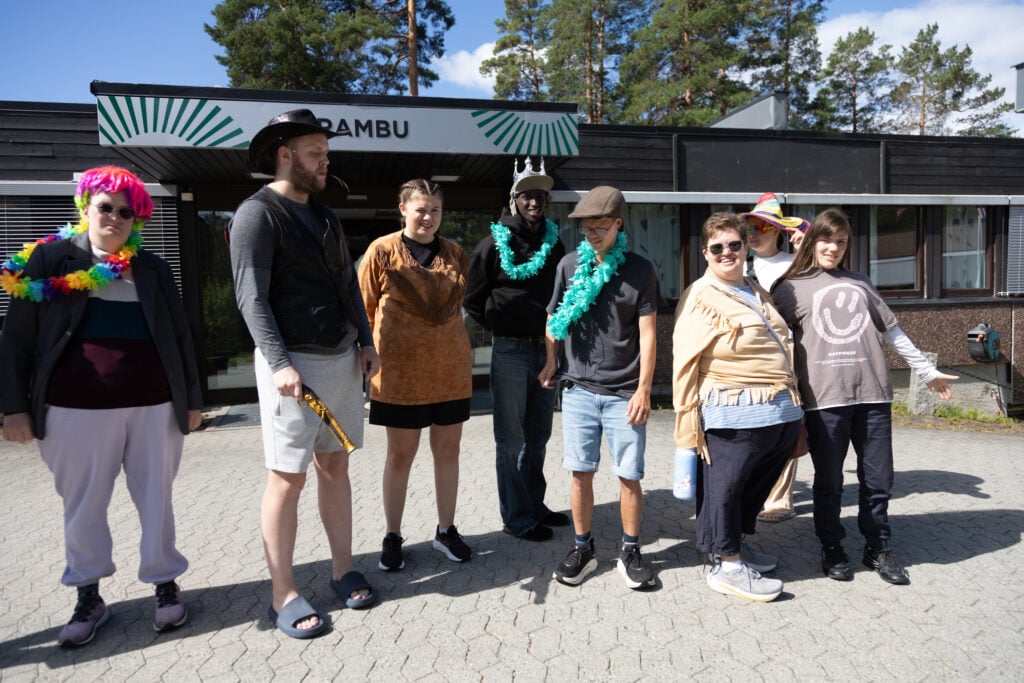 Sju perseoner står utenfor bygg. Skilt med Frambu over inngangen. Personene er utkledd som pirater med hatter og parykker 